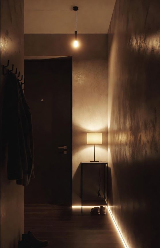 Petite entrée sans fenêtre avec suspension chaude, bande LED discrète et lampe d’appoint, ambiance cosy